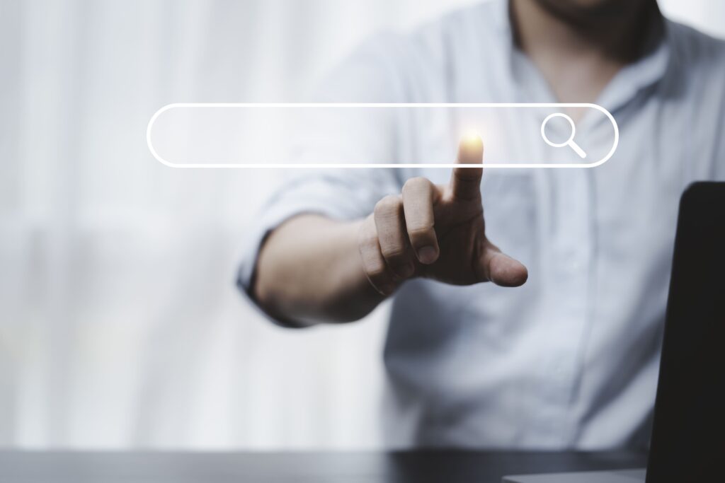Mano tocando el icono de búsqueda - Optimización para motores de búsqueda (SEO) - Concepto - Encontrar información mediante conexión a Internet