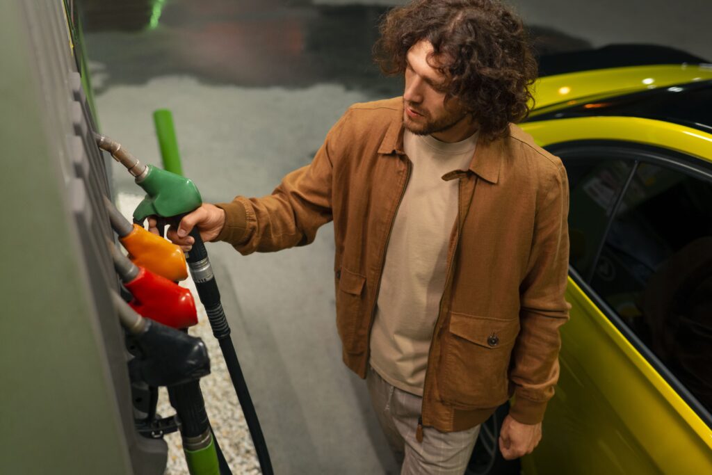 hombre de ángulo alto en gasolinera